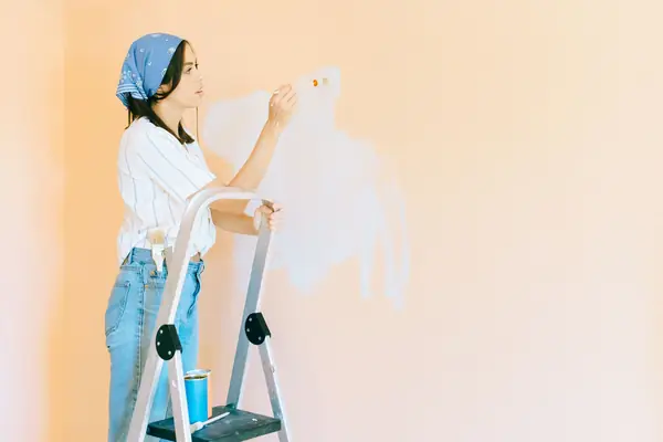 Interior painting in Stockton: painter on a stepladder rolling a wall